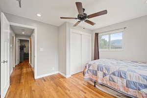 Bedroom featuring light wood finished floors, a closet, recessed lighting, and a ceiling fan