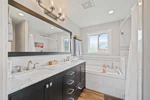 Full bath with a bath, a tile shower, wood finished floors, double vanity, and recessed lighting