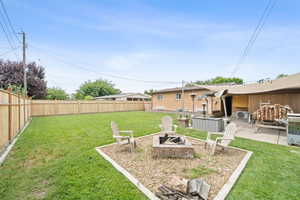 Fenced backyard featuring an outdoor fire pit and a patio