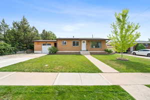 Ranch-style house featuring an attached garage, brick siding, and concrete driveway