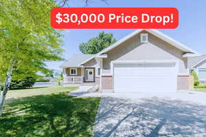 View of front of house featuring covered porch, concrete driveway, stucco siding, a front yard, and an attached garage