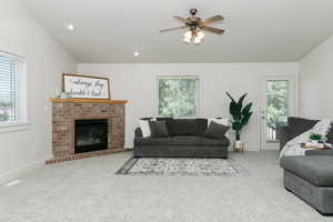 Living room featuring healthy amount of natural light, carpet floors, a ceiling fan, a fireplace, and recessed lighting