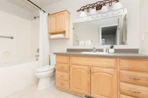 Bathroom featuring tile patterned floors, vanity, and shower / tub combo with curtain
