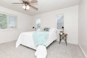 Bedroom with light colored carpet and a ceiling fan