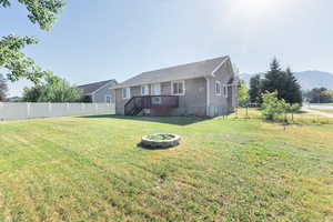 Back of house with a fenced backyard, stucco siding, and a deck with mountain view
