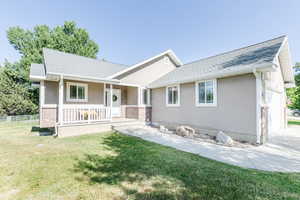 Ranch-style house with covered porch, an attached garage, stucco siding, and a shingled roof