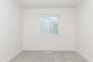 Carpeted empty room with baseboards