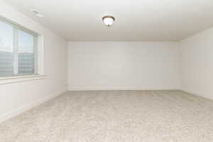Spare room featuring carpet flooring and baseboards