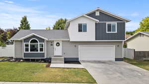 Two Story style home featuring a garage, board and batten siding, driveway, and roof with 4 year old shingles.