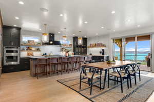 Dining area with recessed lighting, light wood-type flooring, and a water view