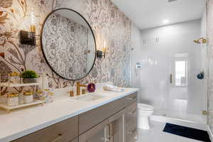 Full bath featuring wallpapered walls, vanity, a stall shower, and tile patterned flooring