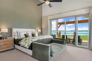 Carpeted master bedroom with access to exterior, a water and mountain view, a high ceiling, and ceiling fan