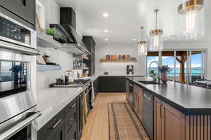 Kitchen with open shelves, stainless steel appliances, recessed lighting, light wood finished floors, and decorative backsplash