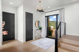 Entryway featuring wood finished floors, a chandelier, recessed lighting, and stairway