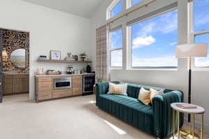 Junior sweet bedroom with wine cooler, healthy amount of natural light, light carpet, high vaulted ceiling, and a bar