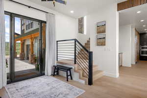 Entryway featuring light wood finished floors, recessed lighting, and stairway