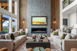 Living area with a towering ceiling and a tiled fireplace