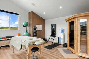 Bedroom with lofted ceiling, light wood-type flooring, and recessed lighting