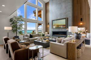 Living room featuring a high ceiling, plenty of natural light, a tiled fireplace, and recessed lighting