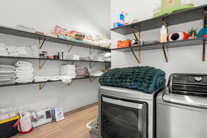 Laundry room with separate washer and dryer and wood finish floors