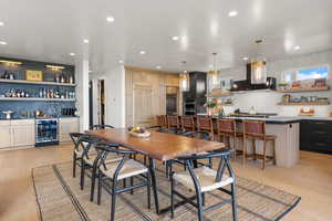 Dining room featuring wine cooler, bar area, recessed lighting, and light wood-style flooring