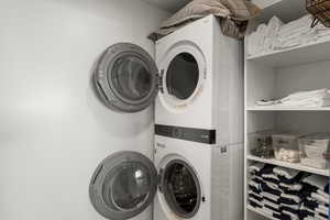 Down stairs laundry. Washroom with stacked washer / dryer