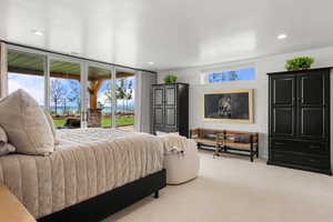 Bedroom featuring access to exterior, multiple windows, carpet flooring, and recessed lighting