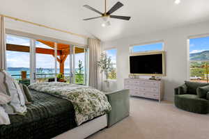 Master bedroom with access to outside, vaulted ceiling, light colored carpet, recessed lighting, and ceiling fan