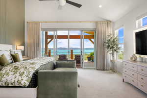 Master bedroom featuring access to outside, light colored carpet, multiple windows, and high vaulted ceiling