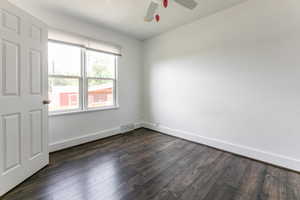 Empty room with dark wood-style flooring and ceiling fan