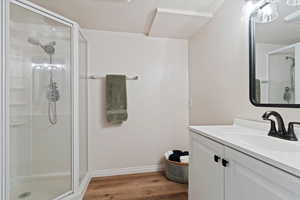Bathroom with a stall shower, vanity, and wood finished floors
