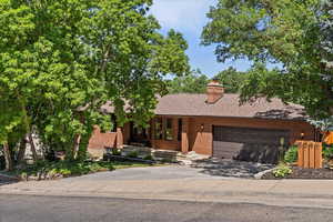 View of front of house with brick siding, a garage, and concrete driveway