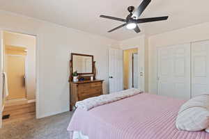 Bedroom with crown molding, a closet, light carpet, and a ceiling fan