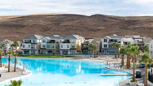 Community pool with a patio, a residential view, and a mountain view