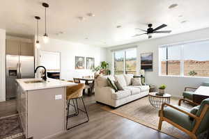 Living area featuring ceiling fan and dark wood-type flooring