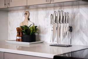 Kitchen view of light countertops, gray cabinets, and backsplash