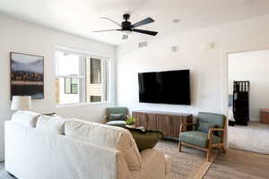 Living room with a ceiling fan and wood finished floors