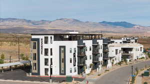 View of building exterior with a mountain view and parking