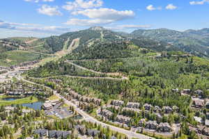 Aerial view of property and surrounding area with a heavily wooded area and a water and mountain view