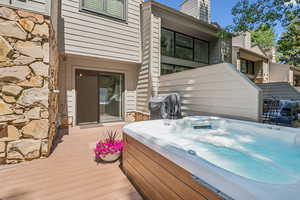 Wooden deck featuring a hot tub and grilling area