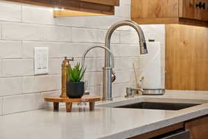 Kitchen view of light stone countertops and decorative backsplash