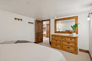 Bedroom with light carpet and baseboards