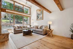 Living room with beamed ceiling and wood-type flooring