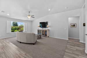 Living area with tile & carpet floors, ceiling fan, lofted ceiling, and recessed lighting