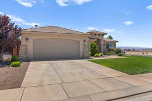 View of front of property with stone siding, stucco siding, and a garage