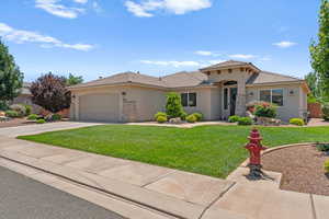 Mediterranean / spanish-style home with stucco siding, a tiled roof, a front yard, an attached garage, and driveway