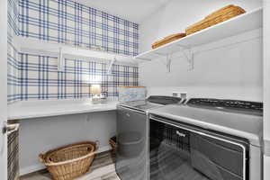 Laundry room with washer/dryer, folding area and wallpaper accent wall