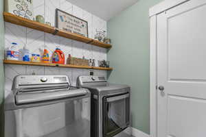 Laundry room featuring separate washer and dryer and baseboards
