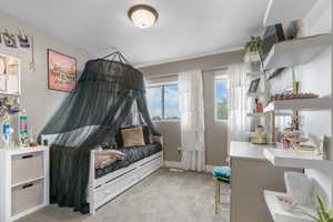 Bedroom featuring light colored carpet and baseboards