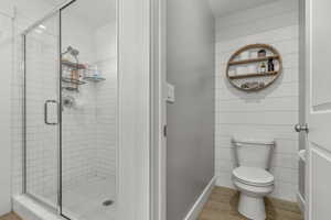 Bathroom with wood finished floors and a stall shower
